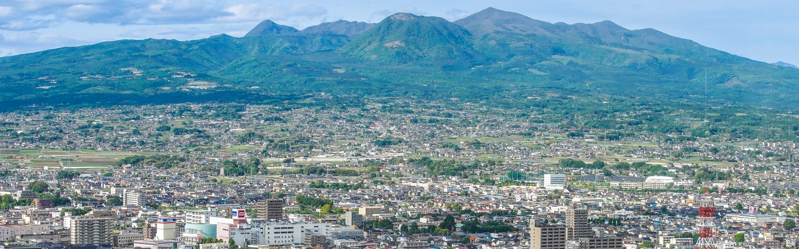 群馬県庁から見下ろした前橋の市街地と、奥に連なる山並みの写真