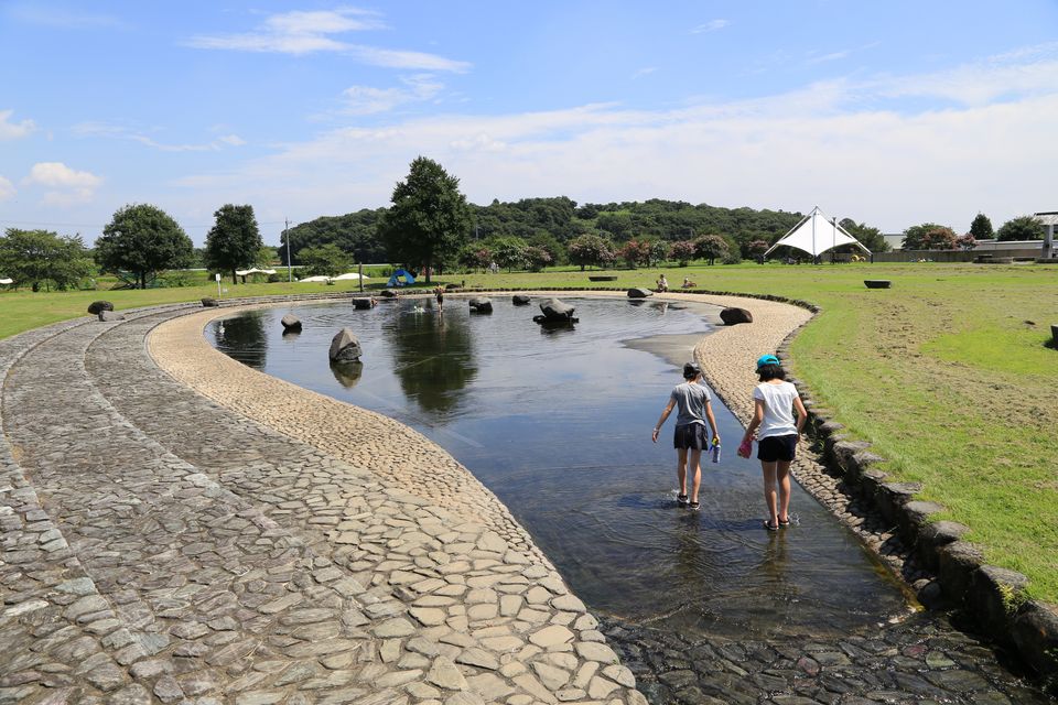 大室公園の親水公園で、浅い水路を歩いて水遊びをする子どもたちの写真